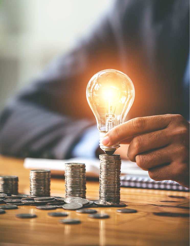 Savings business accountant hand holding financial light bulb concept financial background on the table where the morning sun shines